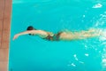 Woman athlete swimming crawl stroke in pool.