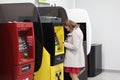 Woman at ATMs of different banks for banking operations. Moscow.
