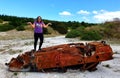 Woman atop overturned burnt out car