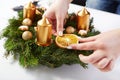 Woman attaches orange on Christmas wreath