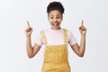 Woman attending great festival, wanting ride on air balloon, standing impressed and amazed in cute yellow overalls