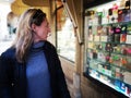 Woman attracted by shop window of a perfumery display showcase