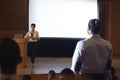 Woman from the audience standing and asking query in the auditorium