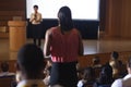 Woman from the audience standing and asking query in the auditorium