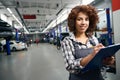 Woman auto mechanic in a repair shop fills out paperwork