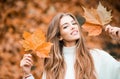 Woman with autumn leaves. Girl with orange leaves. Season and autumn holiday. Beauty and fashion. Smiling model with