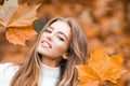 Woman with autumn leaves. Girl with orange leaves. Season and autumn holiday. Beauty and fashion. Smiling model with