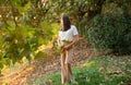 Woman with autumn leaves in hand and fall yellow maple garden background. Royalty Free Stock Photo