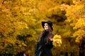 Woman with autumn leaves in hand and fall yellow maple garden background Royalty Free Stock Photo