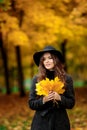 Woman with autumn leaves in hand and fall yellow maple garden background Royalty Free Stock Photo