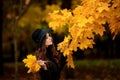 Woman with autumn leaves in hand and fall yellow maple garden background Royalty Free Stock Photo