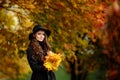 Woman with autumn leaves in hand and fall yellow maple garden background Royalty Free Stock Photo