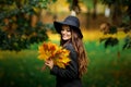 Woman with autumn leaves in hand and fall yellow maple garden background Royalty Free Stock Photo