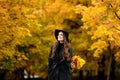 Woman with autumn leaves in hand and fall yellow maple garden background Royalty Free Stock Photo