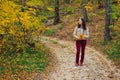 Woman with autumn leaves standing on forest road