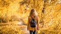Woman in autumn park, back view. Adult girl walking away alone on path in autumn forest Royalty Free Stock Photo
