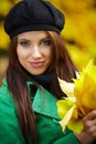 Woman in autumn park holding yellow leaf Royalty Free Stock Photo