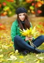 Woman in autumn park holding yellow leaf