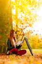 Woman in autumn park using tablet computer reading Royalty Free Stock Photo