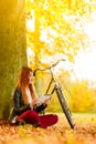 Woman in autumn park using tablet computer reading Royalty Free Stock Photo