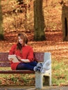 Woman in autumn park using tablet computer reading. Royalty Free Stock Photo