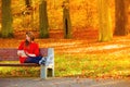 Woman in autumn park using tablet computer reading. Royalty Free Stock Photo