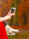 Woman in autumn park using tablet Royalty Free Stock Photo