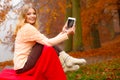 Woman in autumn park using tablet Royalty Free Stock Photo