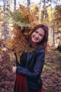 Woman autumn portrait. cute girl outdoors with a bouquet of yellow fern in the forest, autumn fall concept. Royalty Free Stock Photo