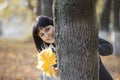 Woman With Autumnal Leaves Behind Tree