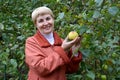 The woman of average years holds in hand apple about an apple-tree Royalty Free Stock Photo