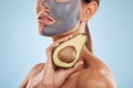 Woman, avocado and face mask for skincare, natural beauty and vitamin d benefits on studio, blue background. Person or