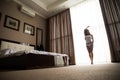 Woman is awoke and standing before window. Royalty Free Stock Photo