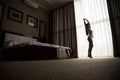 Woman is awoke stretching and standing before window. Royalty Free Stock Photo