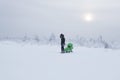 Woman with baby carriage walks in winter snowy area on frosty day Royalty Free Stock Photo