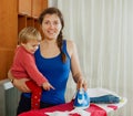 Woman with baby ironing in home Royalty Free Stock Photo