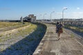 woman from the back with an acoustic guitar moving through the old and disused train station in the city of Barreiro. Royalty Free Stock Photo