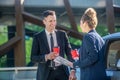 Woman from the back with coffee and papers man near car Royalty Free Stock Photo