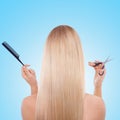 Woman, back and studio with hair, scissors and comb with grooming tools by blue background. Girl, person and model with Royalty Free Stock Photo