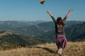 Woman back traveler tosses a hat against the background of the m Royalty Free Stock Photo