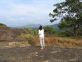 Woman, back view looking at wild monkey in nature, Dambulla, Sri Lanka