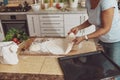 A woman in the background of the kitchen prepares dough for baking pizza in the oven Royalty Free Stock Photo