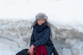 Woman on the background of a winter landscape with large hummocks, frozen ice, Jurmala, Latvia. Winter walk.