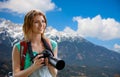 Woman with backpack and camera over alps mountains Royalty Free Stock Photo