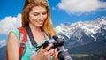 Woman with backpack and camera over alps mountains Royalty Free Stock Photo