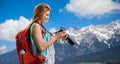Woman with backpack and camera over alps mountains Royalty Free Stock Photo