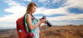 Woman with backpack and camera over mountains Royalty Free Stock Photo