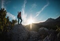 The silhouette of a woman with a backpack against the backdrop of a mountain at sunset Royalty Free Stock Photo