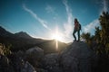 The silhouette of a woman with a backpack against the backdrop of a mountain at sunset Royalty Free Stock Photo