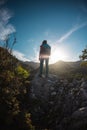 The silhouette of a woman with a backpack against the backdrop of a mountain at sunset Royalty Free Stock Photo